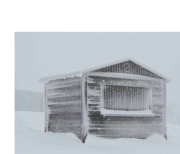 A small wooden house with a snow storm outside